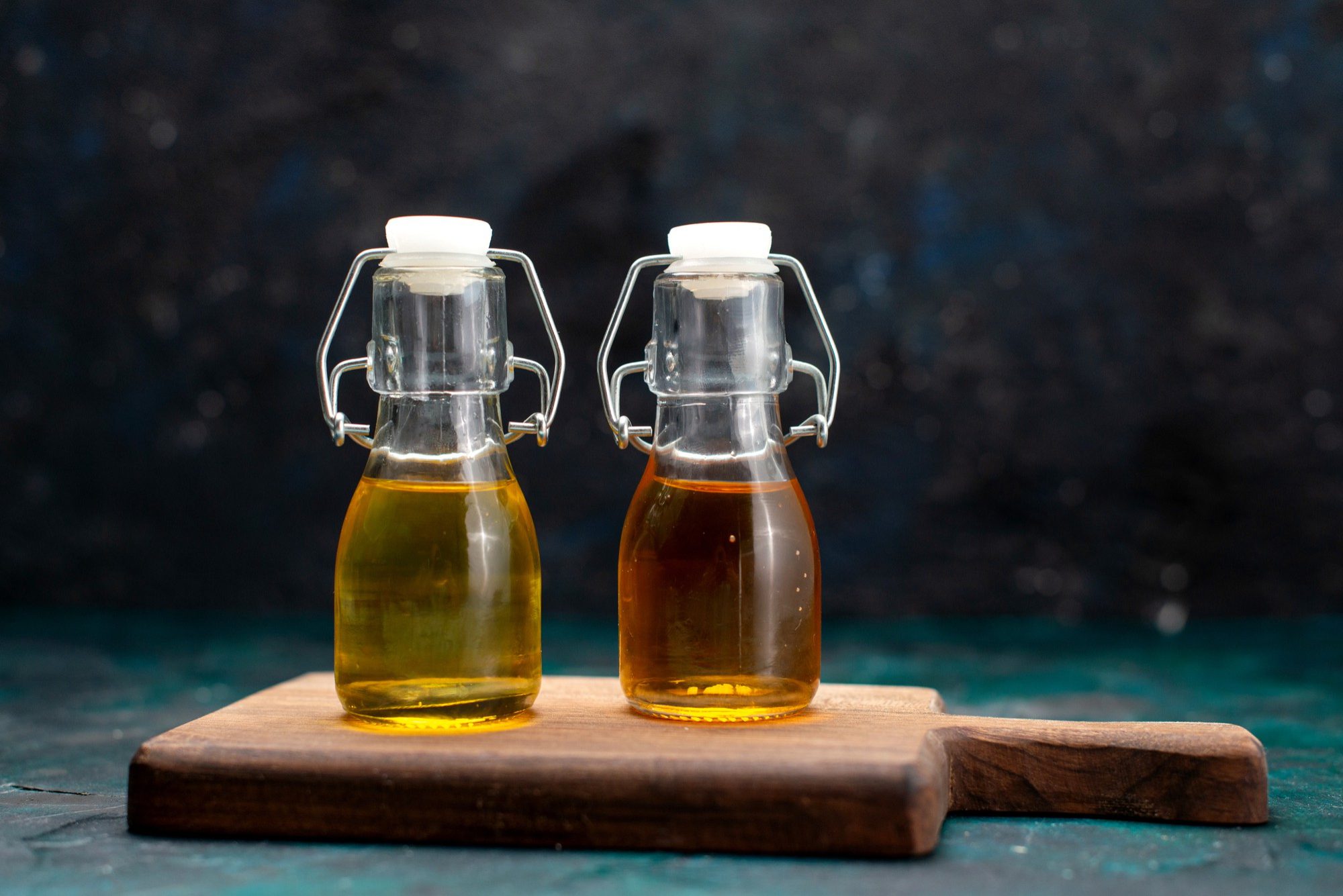 Two bottles of StableMAX cooking oil on a cutting board, ready for culinary use.